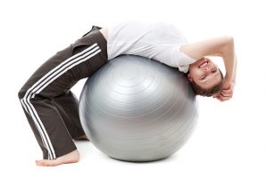 Mujer realizando ejercicio en una pelota de yoga