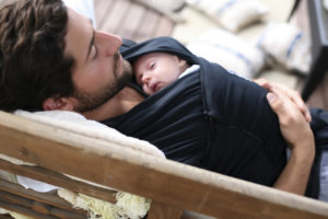 padre usando un canguro para sostener a su bebe