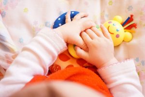 niña sosteniendo el juguete con sus manos