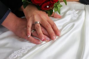 manos de recién casados con sus anillos de compromiso