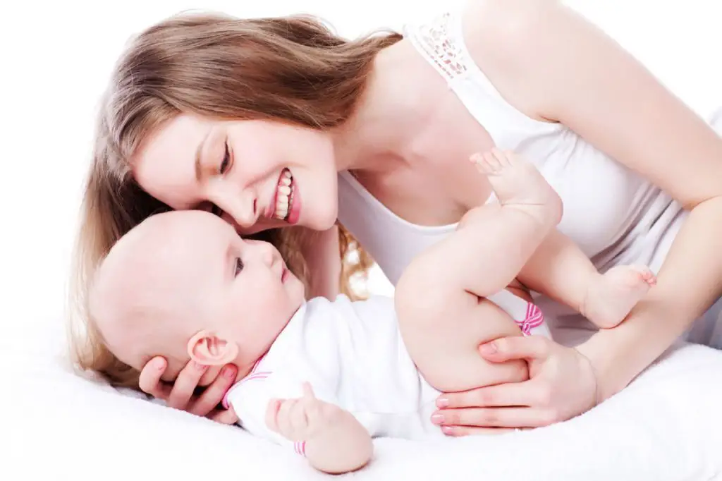 picture of happy mother playing with sweet baby girl over white