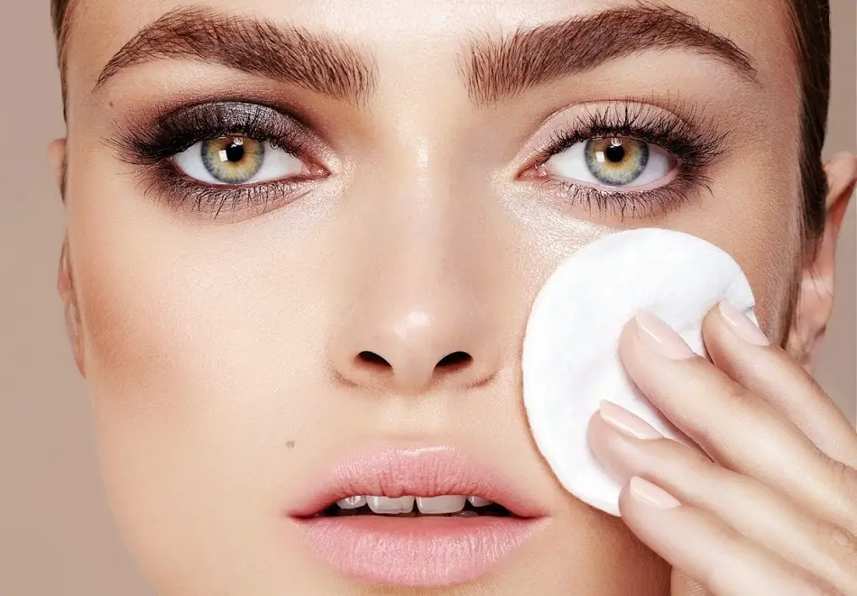 Снятие макияжа с лица. Очищение ресниц перед наращиванием. Снятие макияжа с бровей. Девушка с нарощенными ресницами расчесывает. Демакияж век.