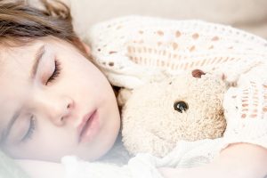 niña durmiendo junto a su peluche