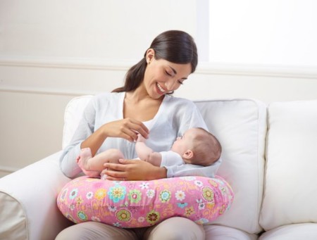 Mujer con almohada de lactancia para alimentar al bebé