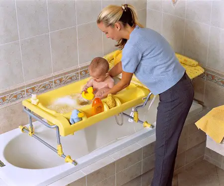 Mujer bañando bebé en bañera de baño con soporte para bañera de casa