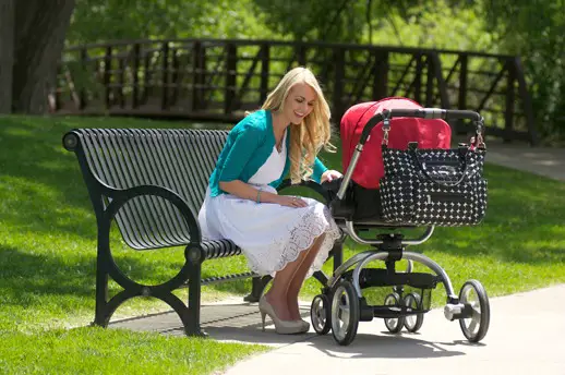Mujer en el parque con el coche de su bebé