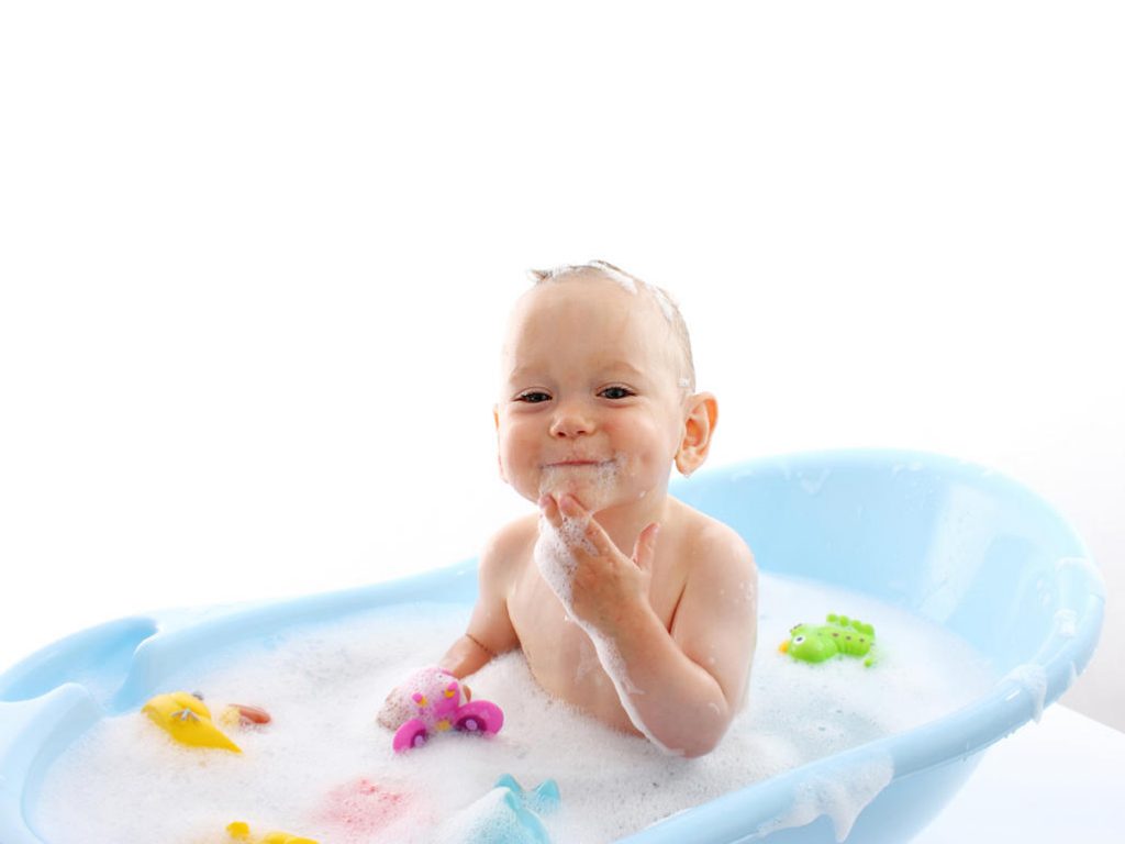 Bebe con la bañera con juguetes de goma