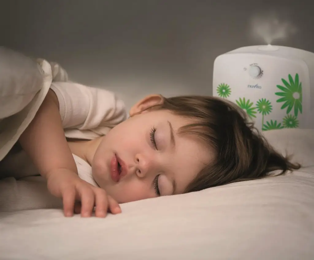 Bebé durmiendo de costado con el uso de un humidificador en su habitación
