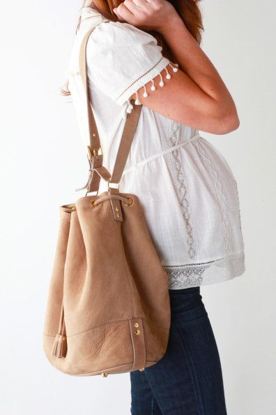 embarazada con ropa de maternidad Embarazada luciendo blusa maternal de perfil con un bolso