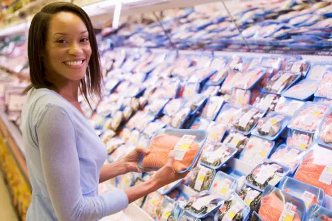 Mujer comprando pescado en un supermercado Mujer comprando pescado en un supermercado