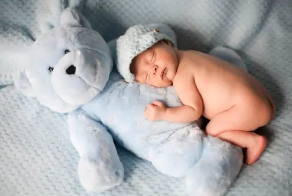 Fotografía de bebé recién nacido con un osito