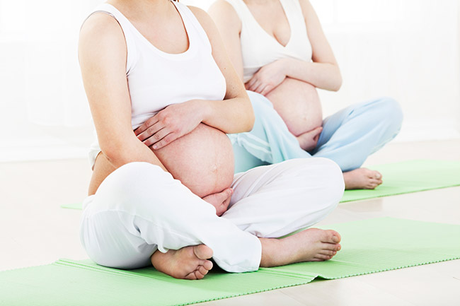 Meditacion guiada para embarazadas Dos mujeres embarazadas sentadas en una meditación guiada