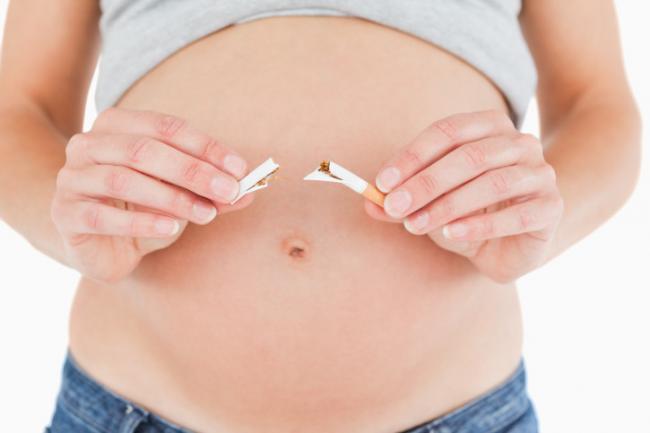 Imagen de embarazada rompiendo un cigarro
