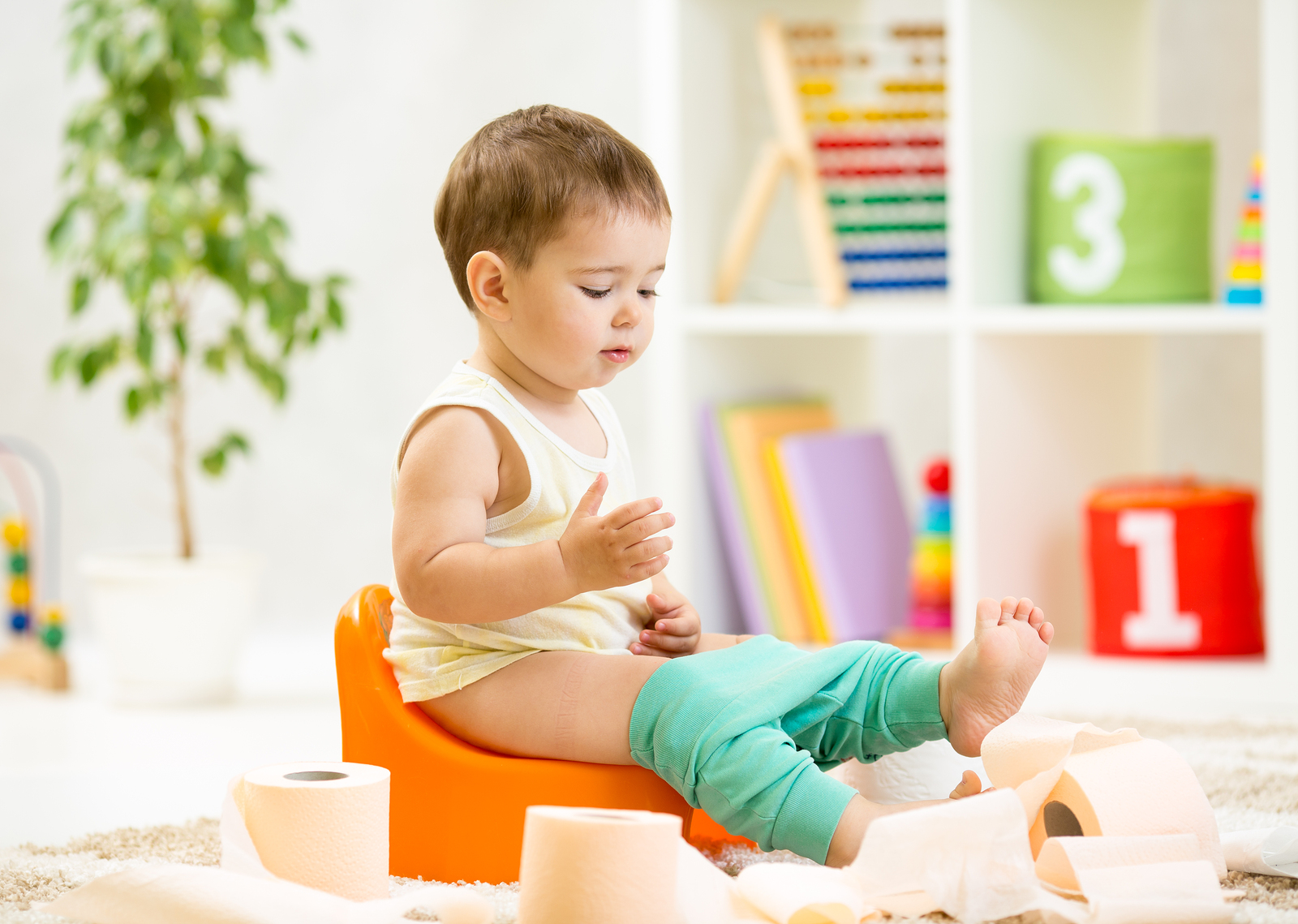 niño pequeño sentado en un toilet de niños