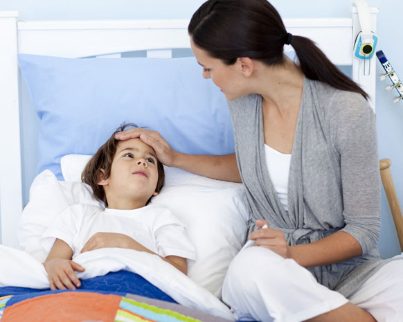 mama sentada en cama con su hijo