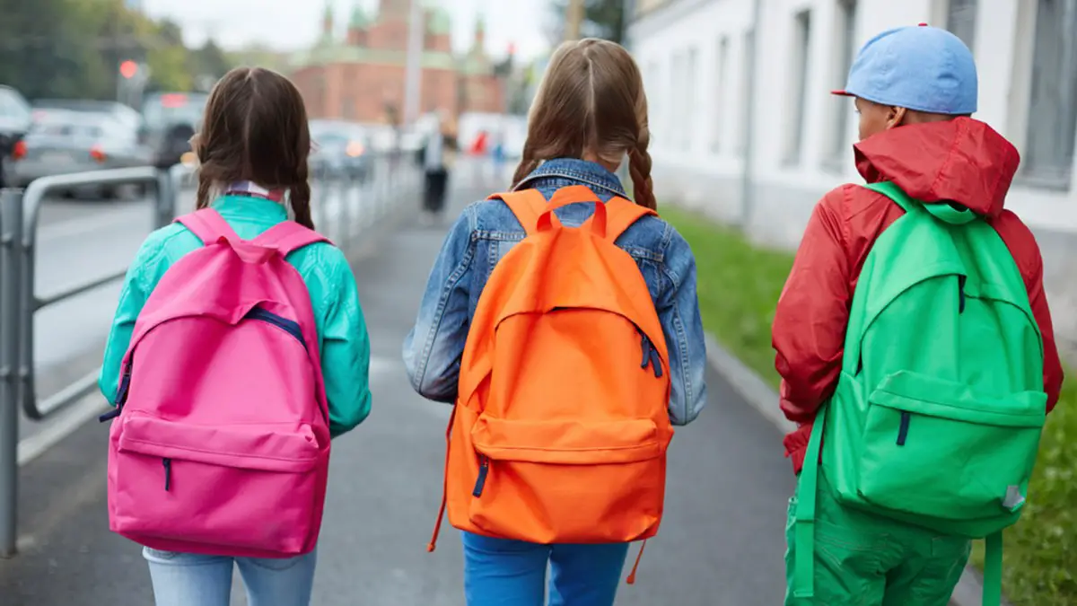 niños con mochilas escolares