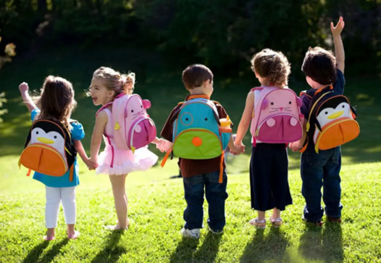 niños felices con mochilas escolares